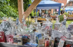 Großer Tisch mit zahlreichen Geschenken und Präsenten, die von Unterstützern und Sponsoren für den Pflegeelternverein bereitgestellt wurden.